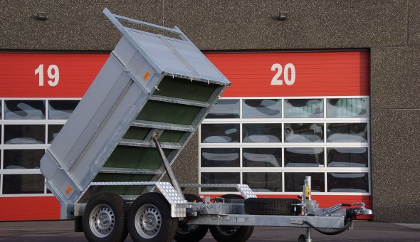 Twin axle tipper trailer with drive plates for transporting machinery