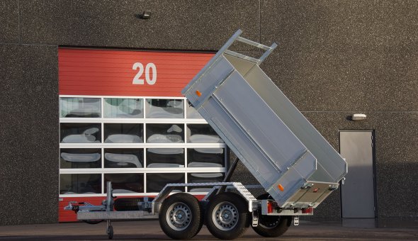 Twin axle tipper trailer with drive plates for transporting machinery